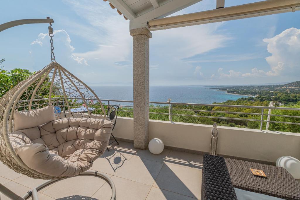 un columpio en un balcón con vistas al océano en Villa Artemis, en Quartu Sant'Elena