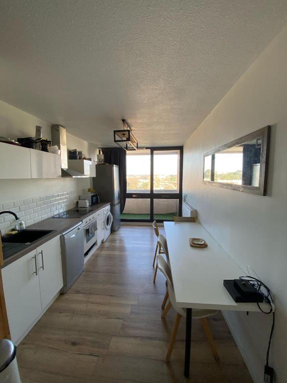 a kitchen with a table and chairs in a room at Appartement spacieux et lumineux, idéalement situé in Pessac