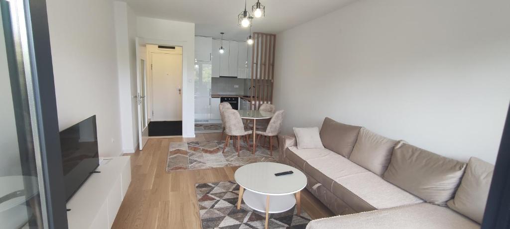 una sala de estar con un sofá y una mesa en Apartman 22, en Trebinje