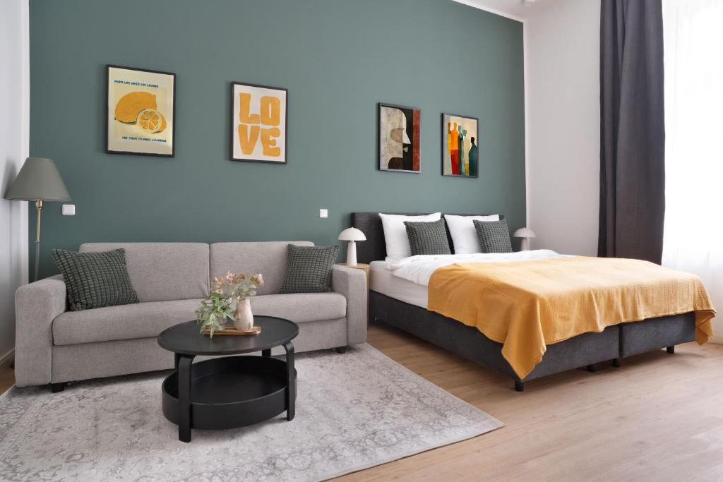 a bedroom with a bed and a couch and a table at Zentrale Apartments I home2share in Halle an der Saale