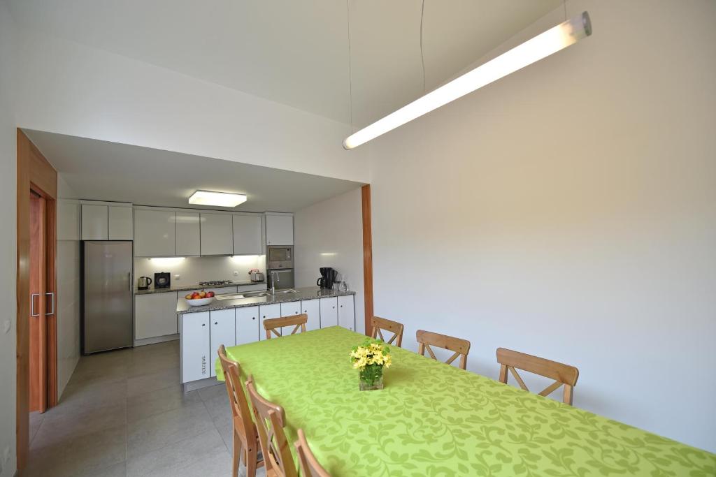 a kitchen with a table with a green table cloth at Casa da Baía - Guest House in Horta
