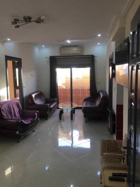 a living room with leather chairs and a table at Nador Boustan N10 in Nador