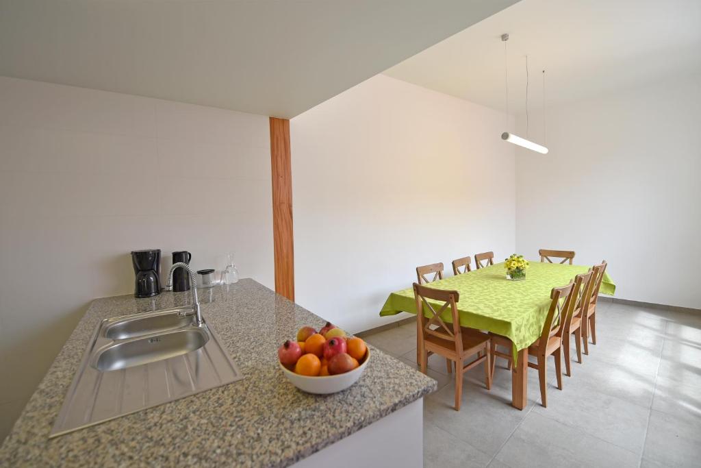 a kitchen with a sink and a table with a bowl of fruit at Casa da Baía - Guest House in Horta