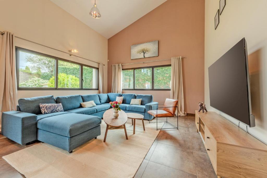 a living room with a blue couch and a flat screen tv at Le Loft, Spacieux 170 m2, Billiards, jardin, 3 chambres in Quimper