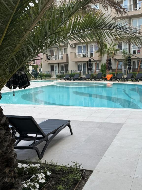 a swimming pool with a bench in front of a building at Sea Home 9 in Sunny Beach