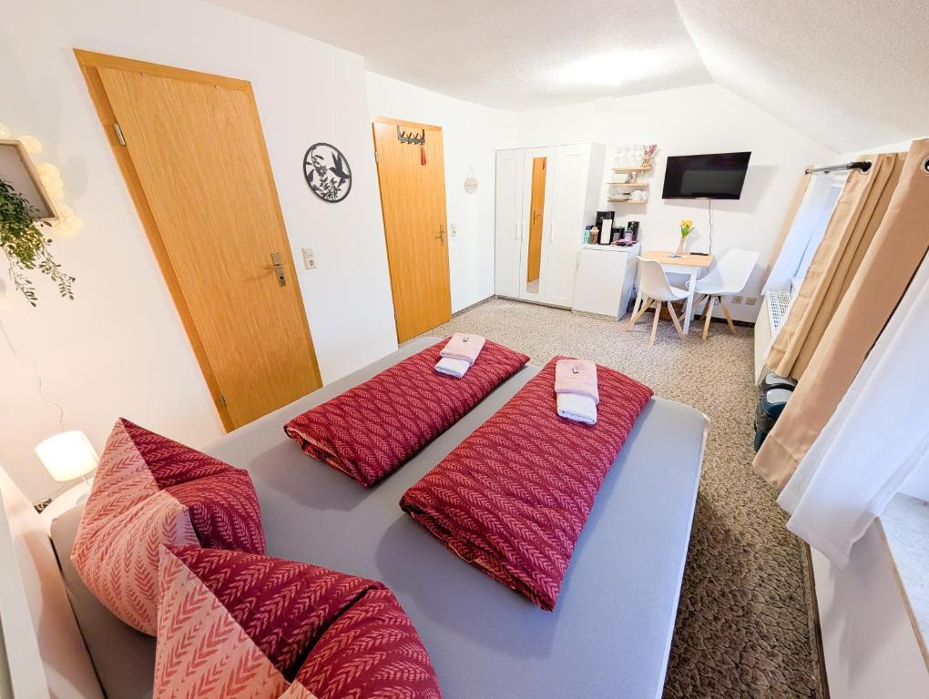 ゼープニッツにあるL4 - Urlaubsmagie - Kleine Wohnung am Wanderwegの赤い枕が置かれたベッドが2つある部屋