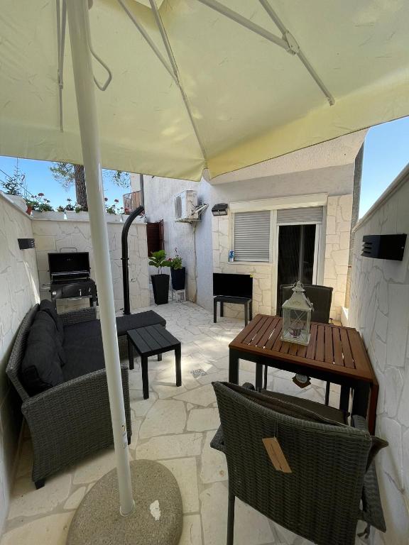 a patio with a table and an umbrella at Seaesta holiday- Modern studio in Okrug Gornji