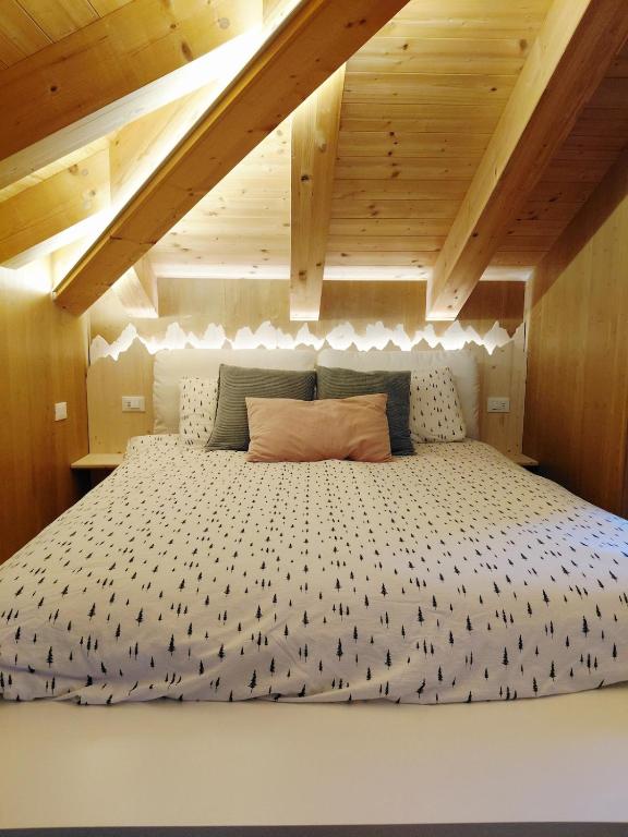 a large bed in a room with wooden ceilings at Casa Marie in Pozzale