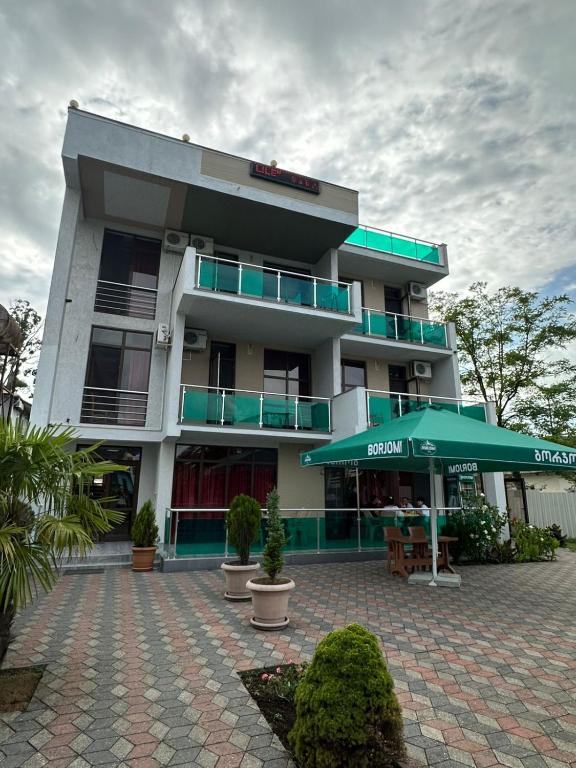 a large building with a green umbrella in front of it at Hotel Lile in Ureki