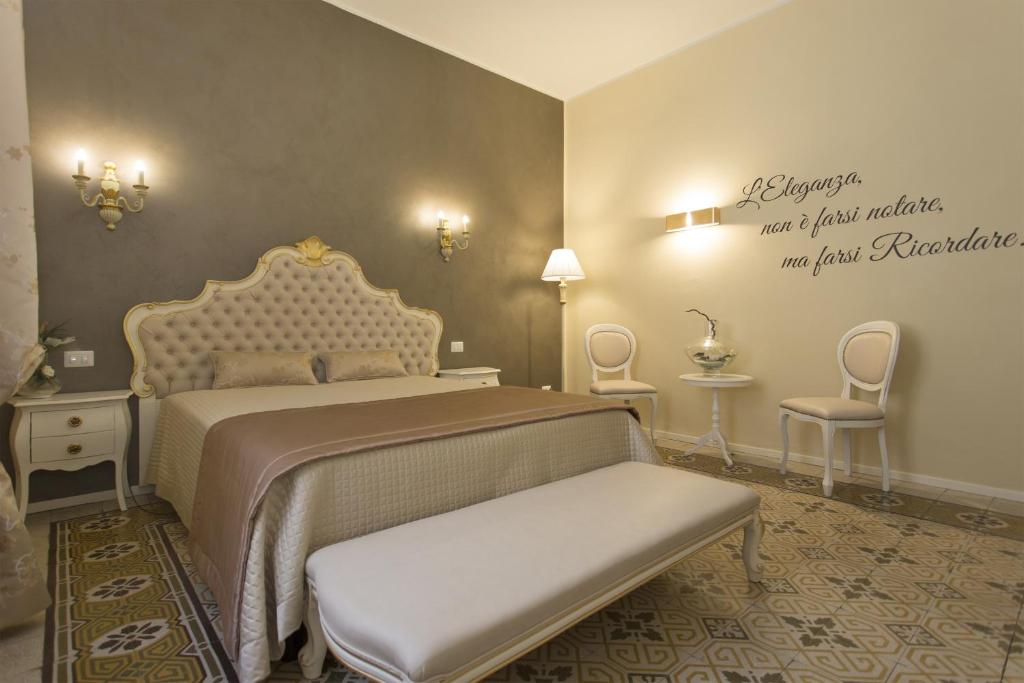 a bedroom with a bed and a bench in it at B&B Villa Anna in Lucca