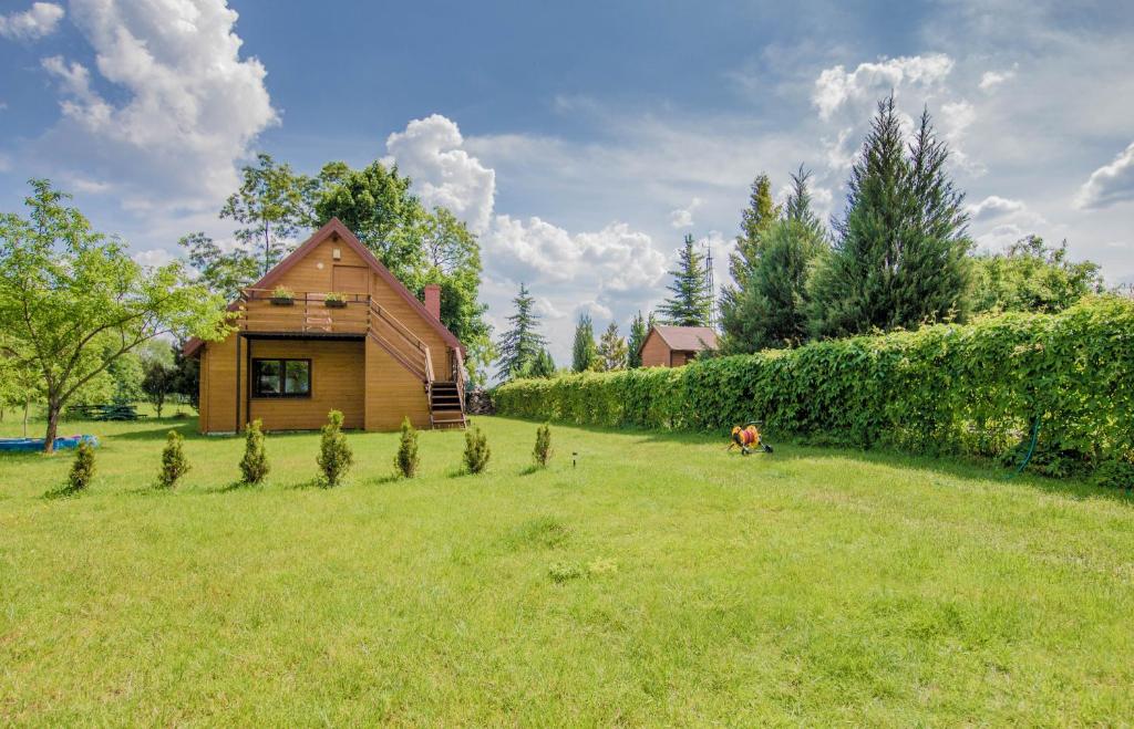 a dog sitting in a yard next to a house at Domek Mikołajki in Mikołajki