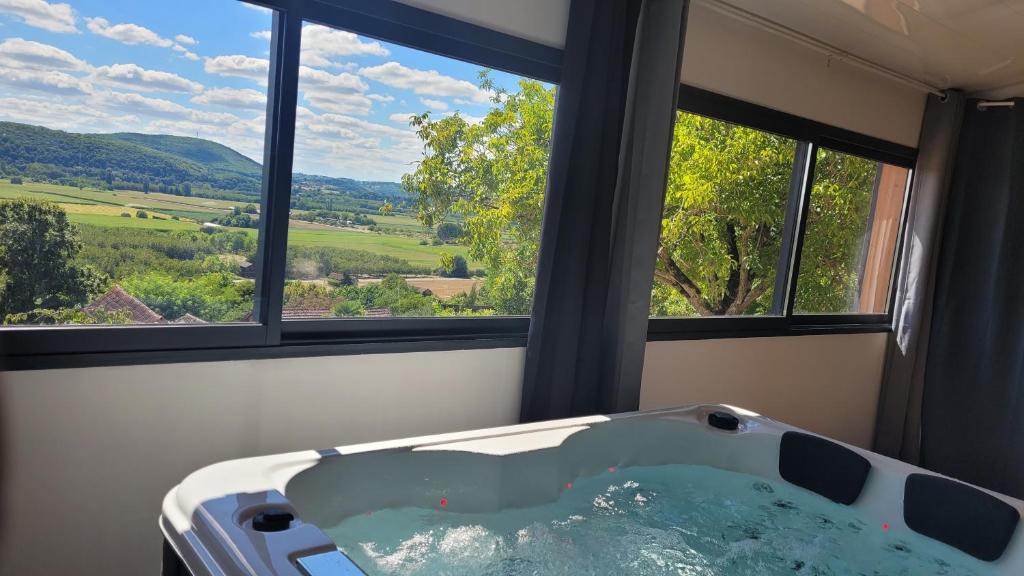 - une baignoire dans une chambre avec 2 fenêtres dans l'établissement NiD'Amour Gîte La Colombe, à Bézenac