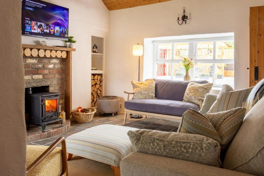 a living room with a couch and a fireplace at The Pilot's Cottage in Cornamucklagh