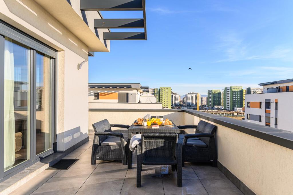 een balkon met een tafel en stoelen op een gebouw bij KOA - Moon Penthouse in Braşov