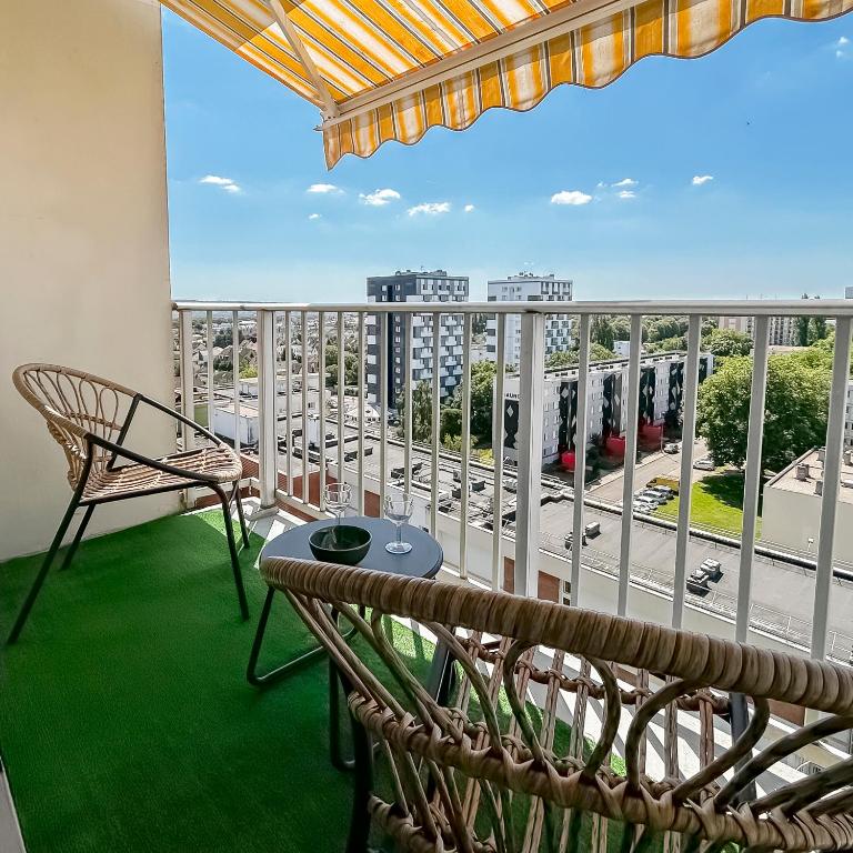 d'un balcon avec une table et des chaises et une vue sur l'autoroute. dans l'établissement Élégance et vue panoramique, proche Zenith, à Saint-Étienne-du-Rouvray