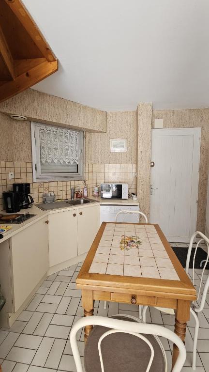 Il comprend une cuisine avec une table et des chaises en bois. dans l'établissement Maison 30m2 Wifi 9mn à Pied Plage Présidents Draps fournis pour le lit, à Les Sables-dʼOlonne