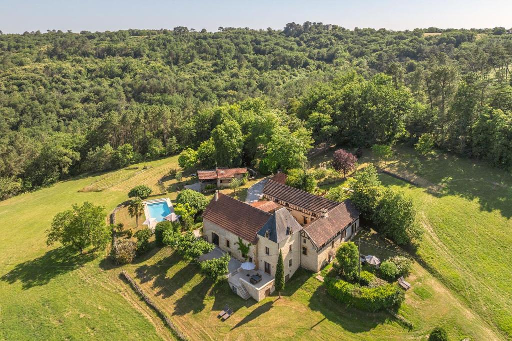une vue aérienne d'une maison dans un champ dans l'établissement Domaine des Grands Bois Privatisé, 9 chambres, 18 personnes, salle de jeux, piscine panoramique privée et chauffée, à Sergeac
