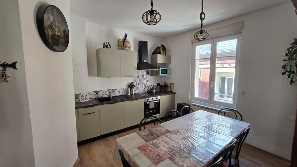 ル・トレポールにあるAppartement plage & portのキッチン(ダイニングルームテーブル、テーブル、椅子付)