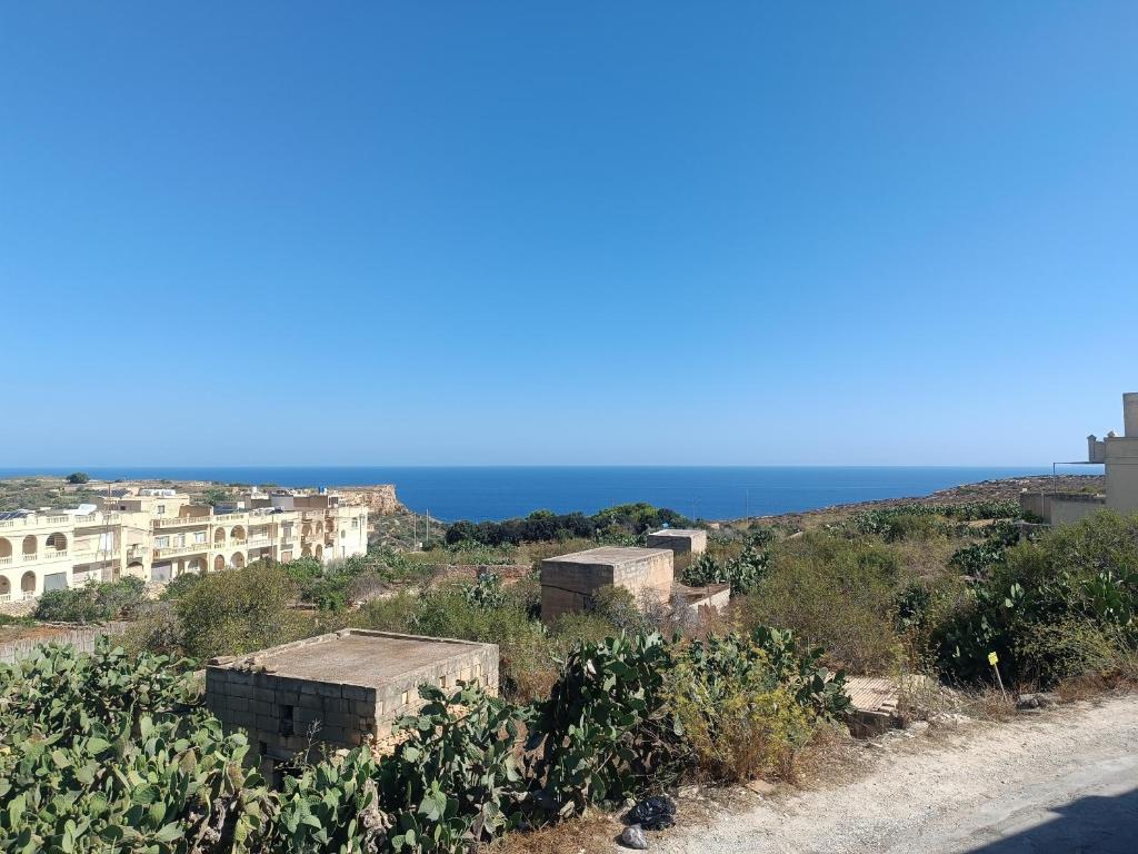a group of buildings on a hill next to the ocean at Boscolo Flats Nadur - Modern Rooms with private en-suite bathrooms in Nadur