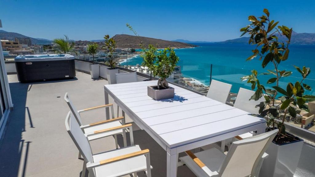 a white table and chairs on a balcony with the water at Skyline penthouse Sarande in Sarandë