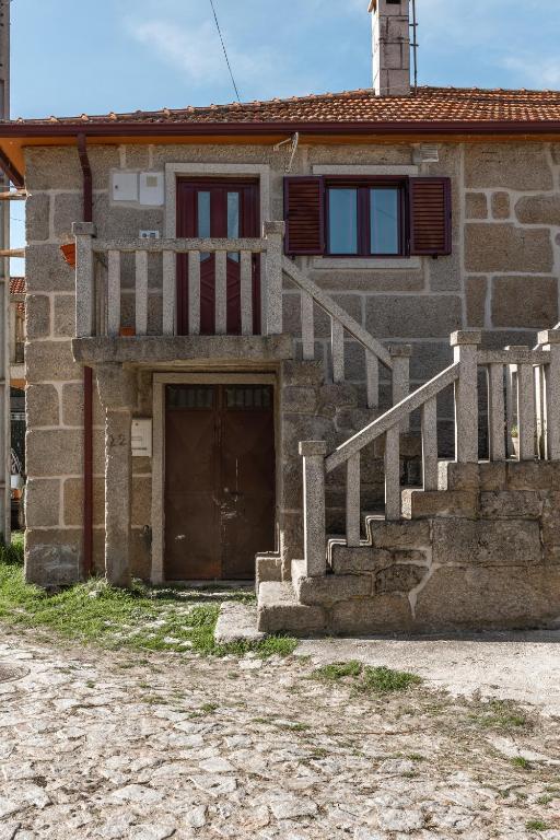 a brick house with a door and stairs in front of it at Casa do Meia Noite in Gralhas