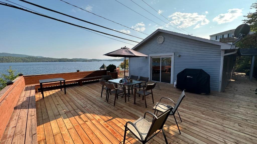 una terrazza con tavolo, sedie e ombrellone di Chalet Bleu a Lac Sainte-Marie