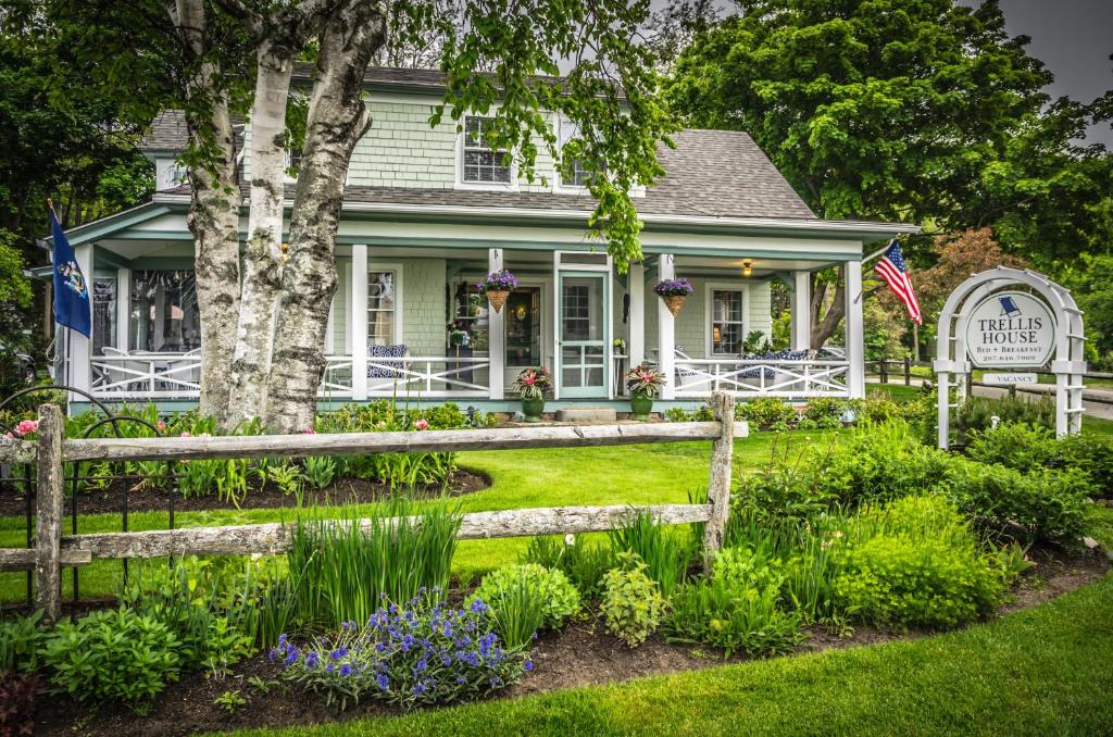 a house with a fence and flowers in the yard at The Trellis House in Ogunquit