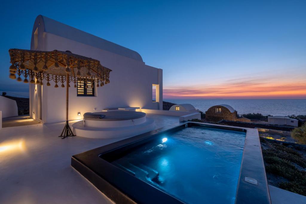 a villa with a swimming pool at night at San Nectar Luxury Villas in Vourvoulos