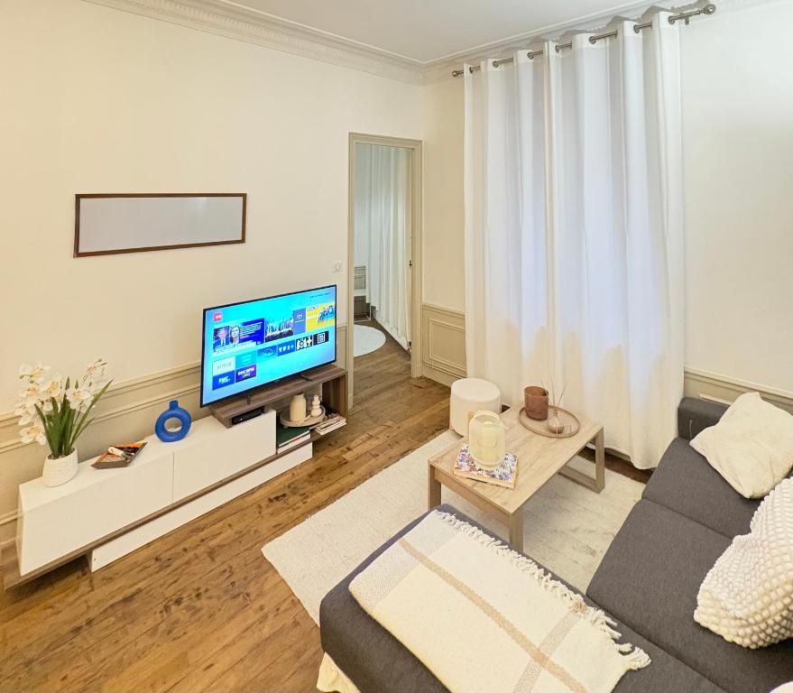 un salon avec un canapé et une télévision dans l'établissement Appartement Privé Chic Paris - Tour Eiffel, à Paris