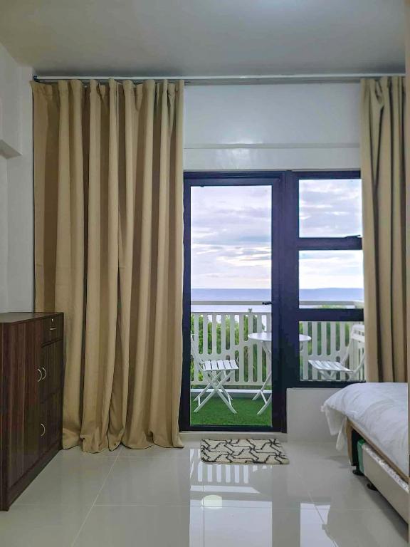 a bedroom with a window with a view of the ocean at Kuya Os Staycation at Royal Oceancrest Condominium Panglao in Dauis