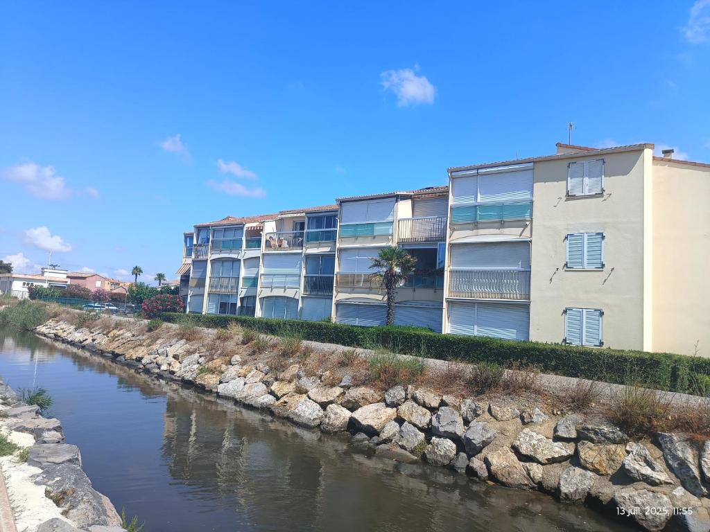 Appartement les flots bleues في فالراس بلاج: عمارة سكنية على جانب النهر