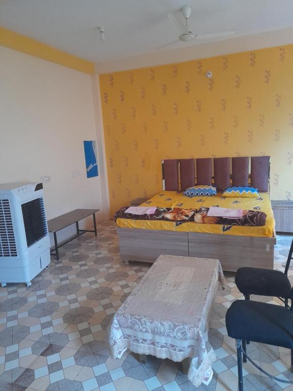 a bedroom with a bed and a table and a tv at Shri Raj Home stay in Ujjain