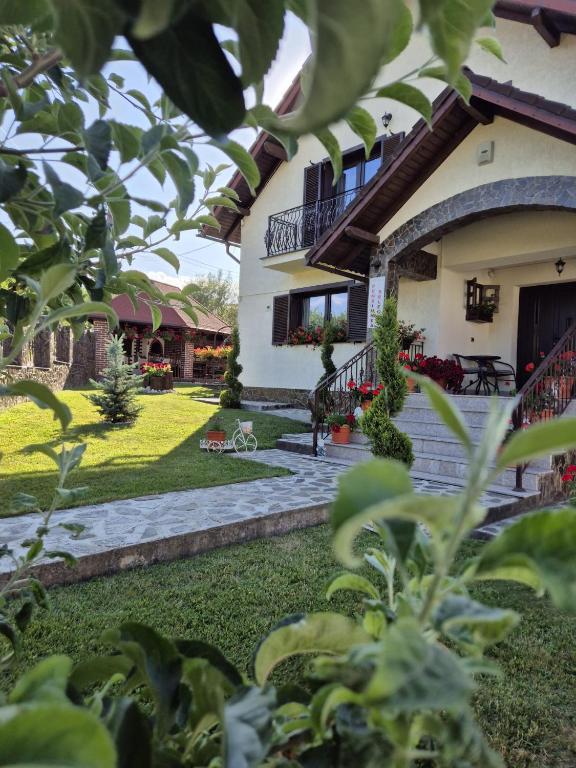 a house with a patio and a yard at Pensiunea Select in Curtea de Argeş