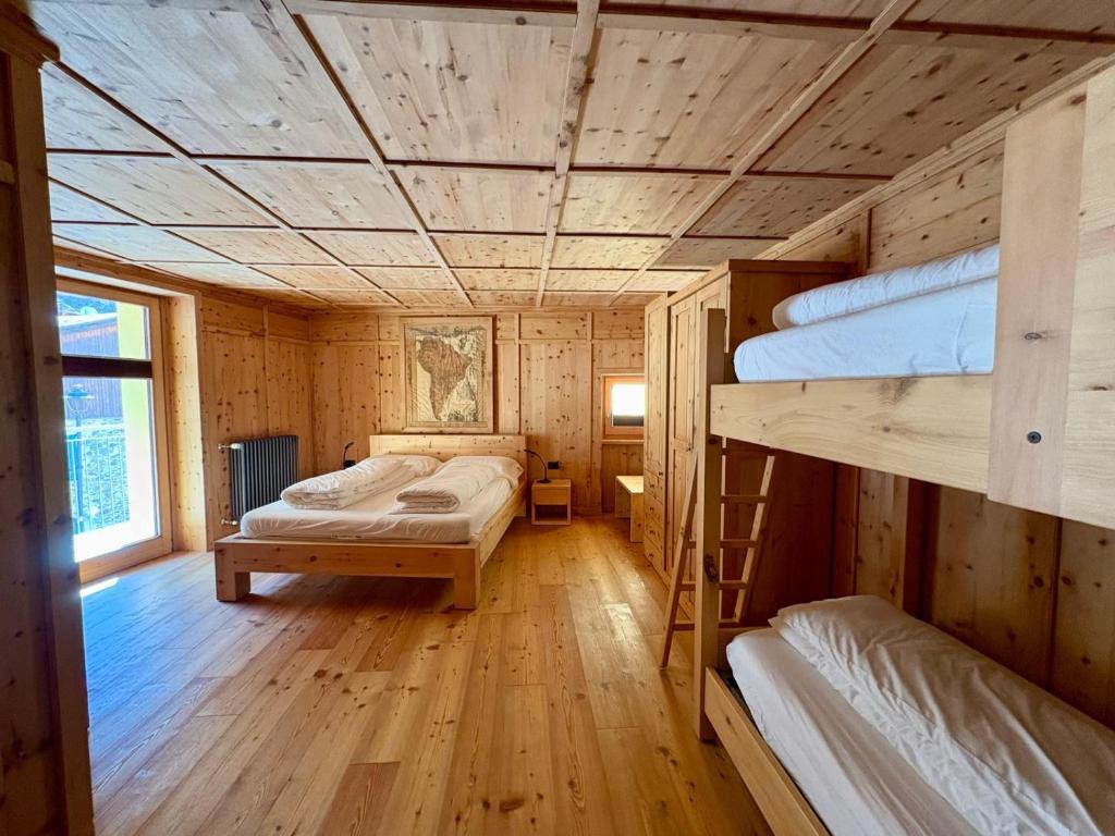 a room with three bunk beds in a cabin at Casa Bavo in Gerola Alta