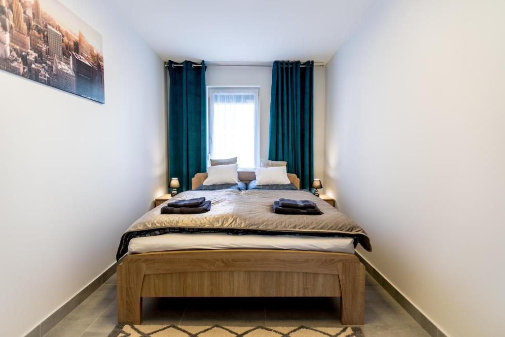 a bedroom with a bed with green curtains at Mátravölgy Apartmanház in Pásztó