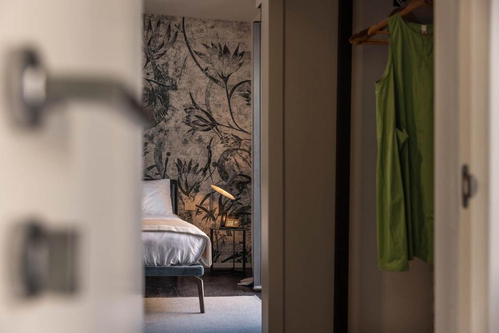 ein Schlafzimmer mit einem Bett und einer Wand mit Tapete in der Unterkunft Arco Vecchio Urban Suite - Epoca Collection in Lecce