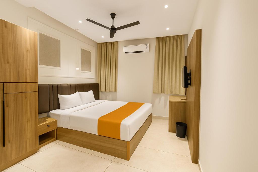 une chambre avec un lit et une télévision dans l'établissement THE HERiTAGE, à Ernakulam