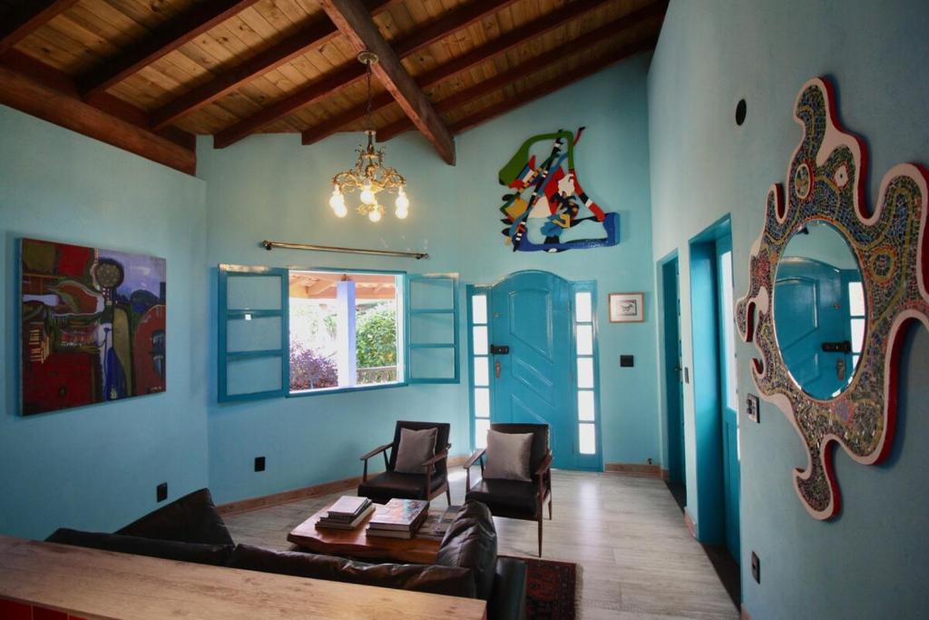 a living room with a couch and a mirror at Casa Arte Flor in São Bento do Sapucaí