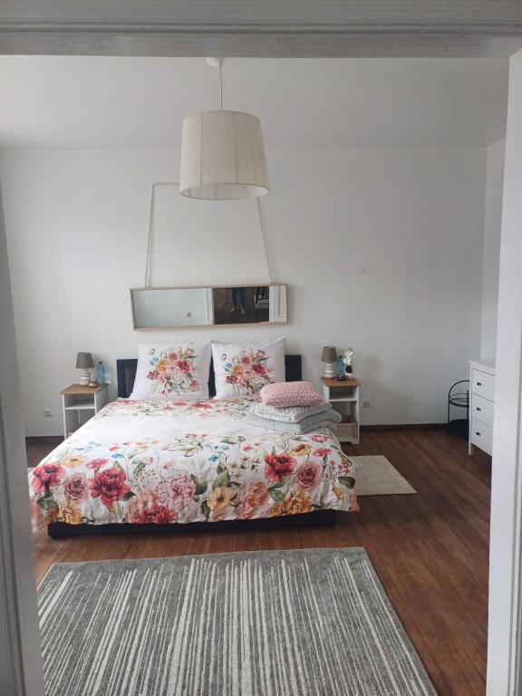 Un dormitorio con una cama con una colcha floral. en Zacisze Pod Nikiszem, en Katowice