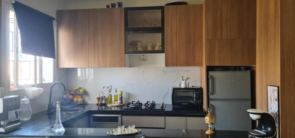 a kitchen with wooden cabinets and a refrigerator at appartement forêt diplomatique in Tangier