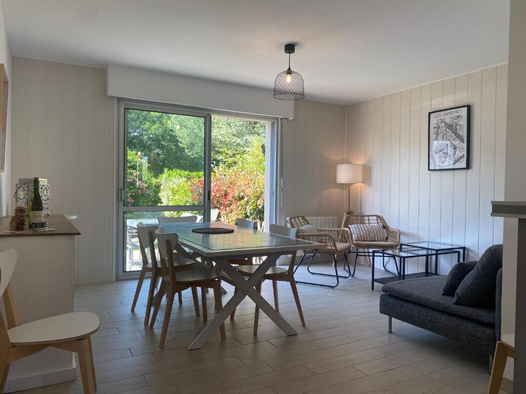 un salon avec une table et des chaises de salle à manger dans l'établissement Villa Fouesnant Beg Meil Ty Bigorn 150 m plage et sentiers, à Fouesnant