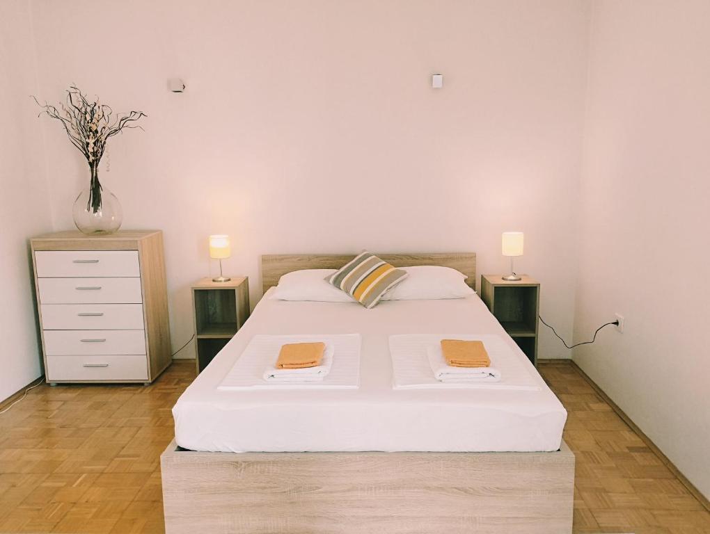 een slaapkamer met een bed met twee nachtkastjes en twee lampen bij Active Apartments Koper in Koper