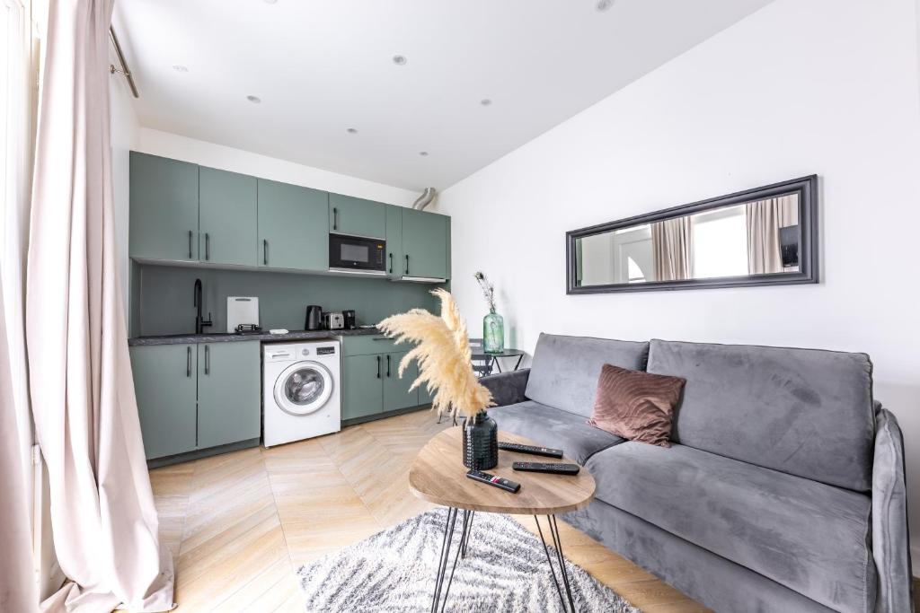 a living room with a gray couch and a table at Apartement 4 stars in Levallois , near Paris 17th district in Levallois-Perret