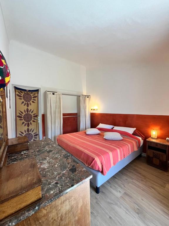 a bedroom with a bed with a red bedspread at La maison colimaçon in Clans