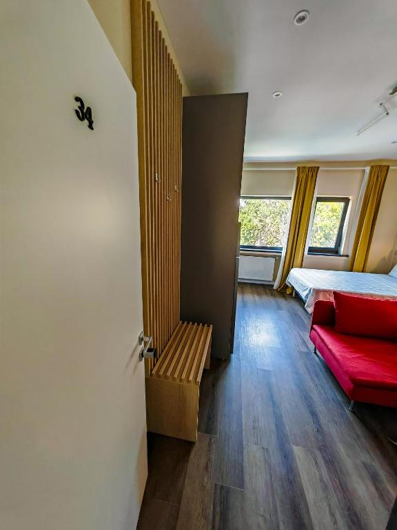 a bedroom with a bed and a red couch at Beautiful new studios&apartments super central location in Bucharest