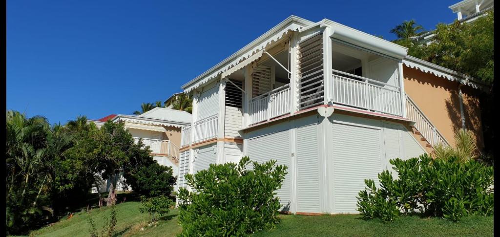 Un edificio blanco con un balcón al costado. en Appartement vue mer Anse des rochers, en Saint-François