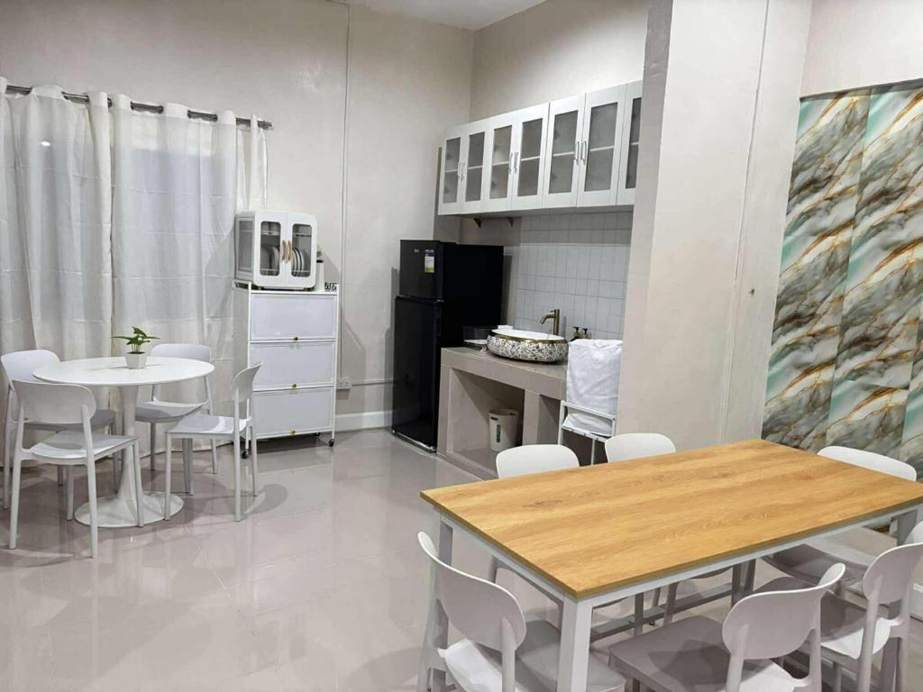 a kitchen and dining room with a table and chairs at 2 bedroom cute log house in Bacolod- near NGC in Bacolod