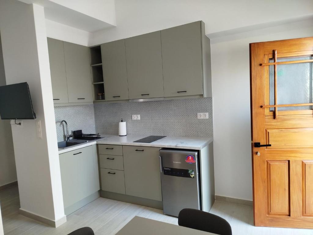 a kitchen with white cabinets and a stainless steel refrigerator at Mary's House 2 in Skiros