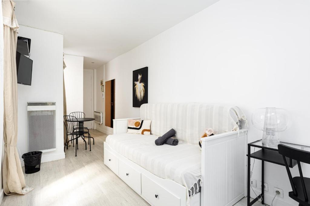 une chambre blanche avec un lit et une table dans l'établissement Charming Room Center of Paris, à Paris