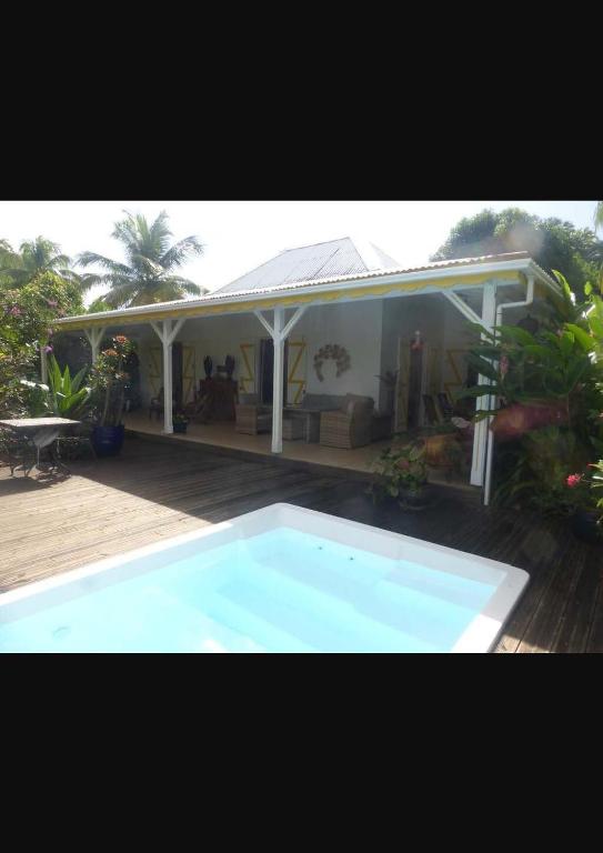 a house with a blue swimming pool in front of it at Villa Kowosol in Le Marin
